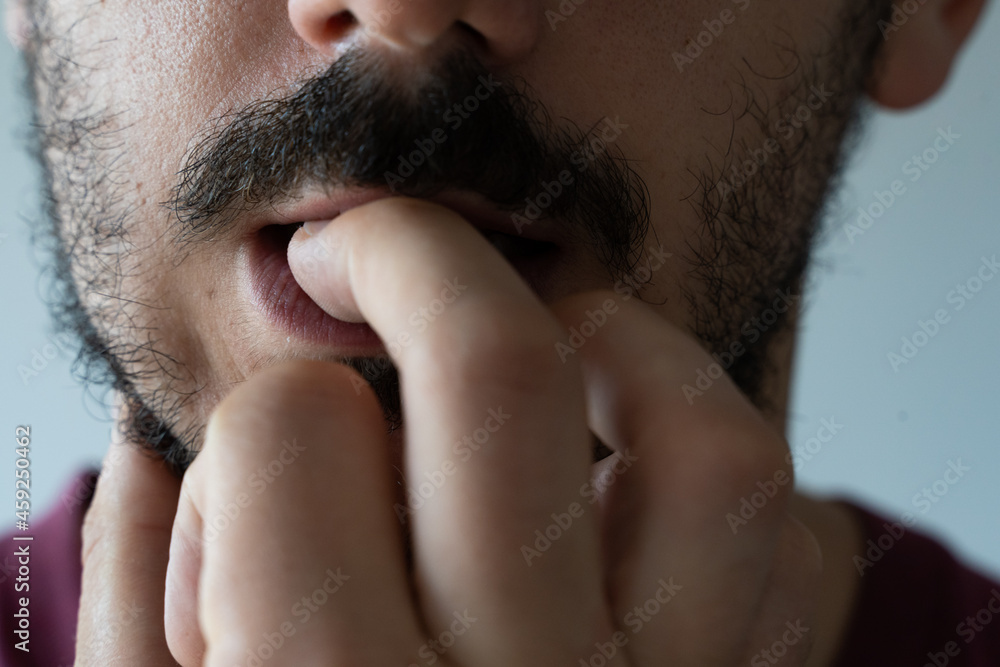 Naklejka premium Extreme close up of young man biting his nails