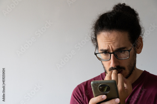 Wallpaper Mural Close up with copy space of anxious man looking at smartphone and biting his nails Torontodigital.ca