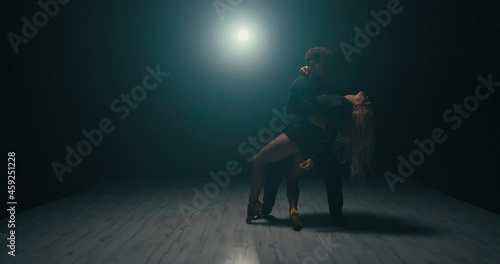Experienced stage dancers spend time training, romantic atmosphere scene in a dark studio, beautiful blonde dancers practice going down to the first floor, slow motion deflection