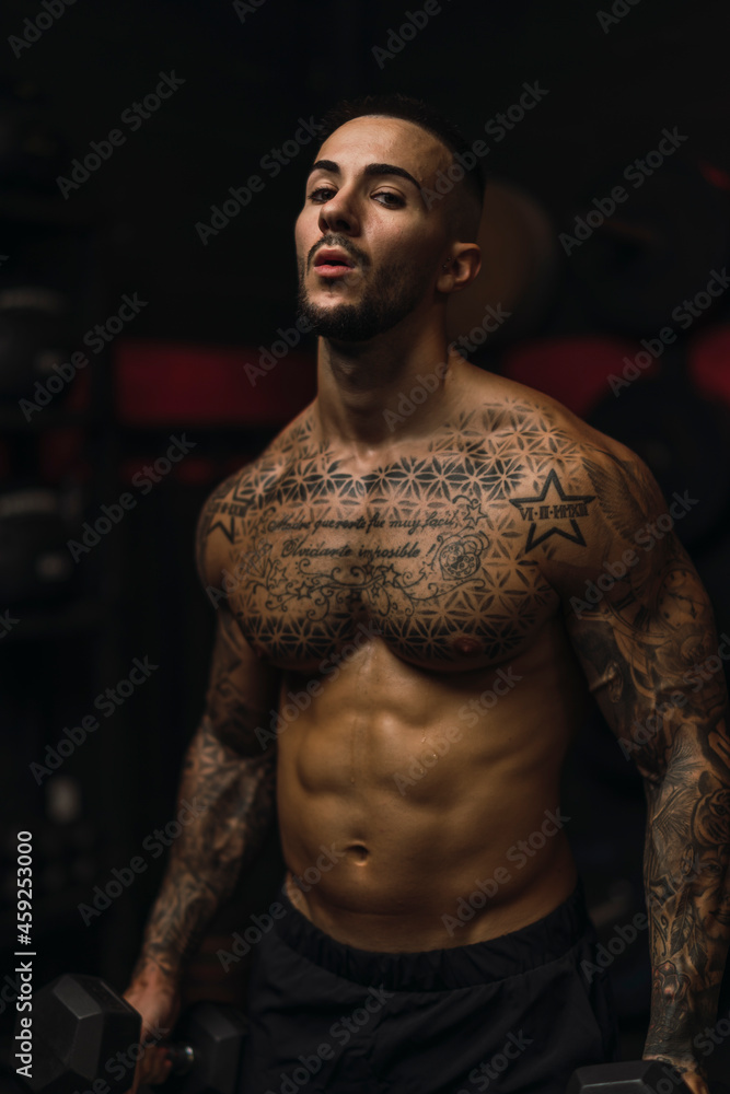 Fototapeta premium Chico atletico sin camiseta y tatuado en un gimnasio de crossfit