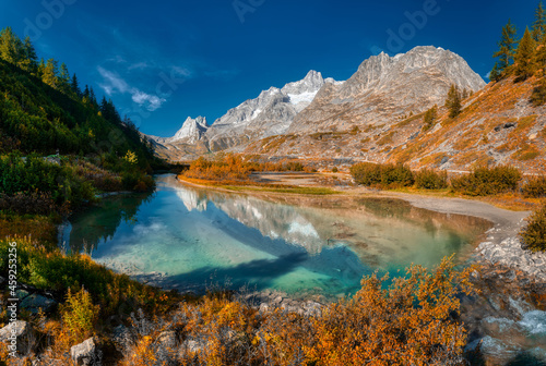 Autumn colors in the wild Val Veny with lake in foreground, Aosta Valley, Italy