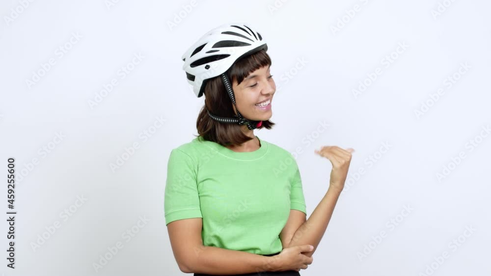 Young woman with bike helmet over isolated background pointing finger to the side and presenting a product over isolated background Young woman with bike helmet over isolated background pointing finger to the side and presenting a product over isolated background