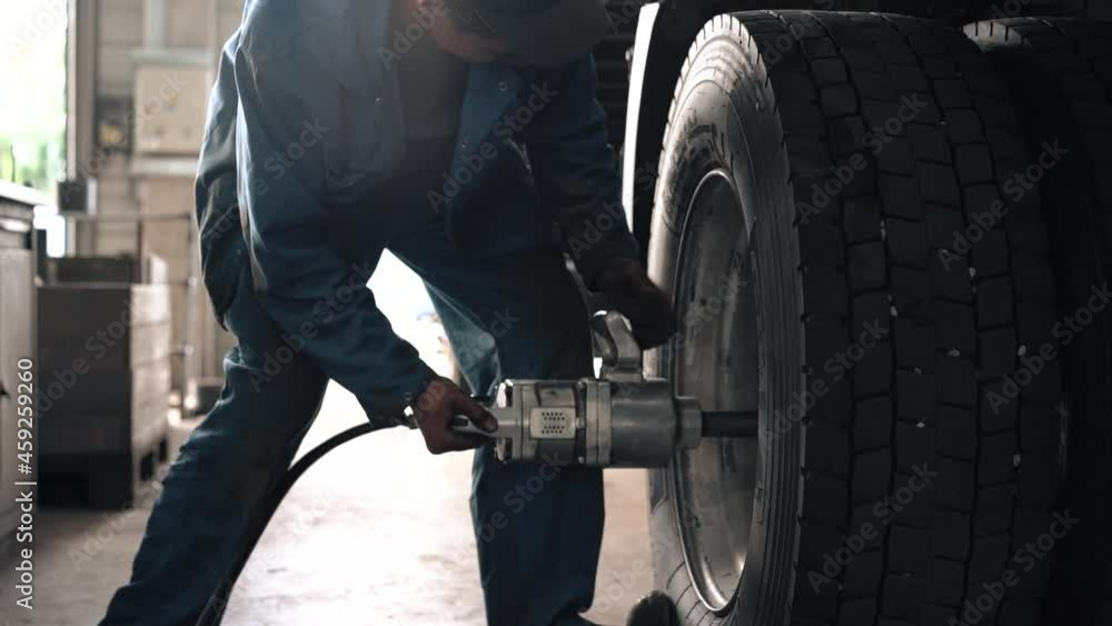 auto mechanic at work. a worker unscrews a car wheel. work in the workshop. breakdown of the truck auto mechanic at work. a worker unscrews a car wheel. work in the workshop. breakdown of the truck