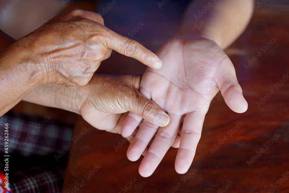 Female fortune teller is reading fortune lines on male palm or hand