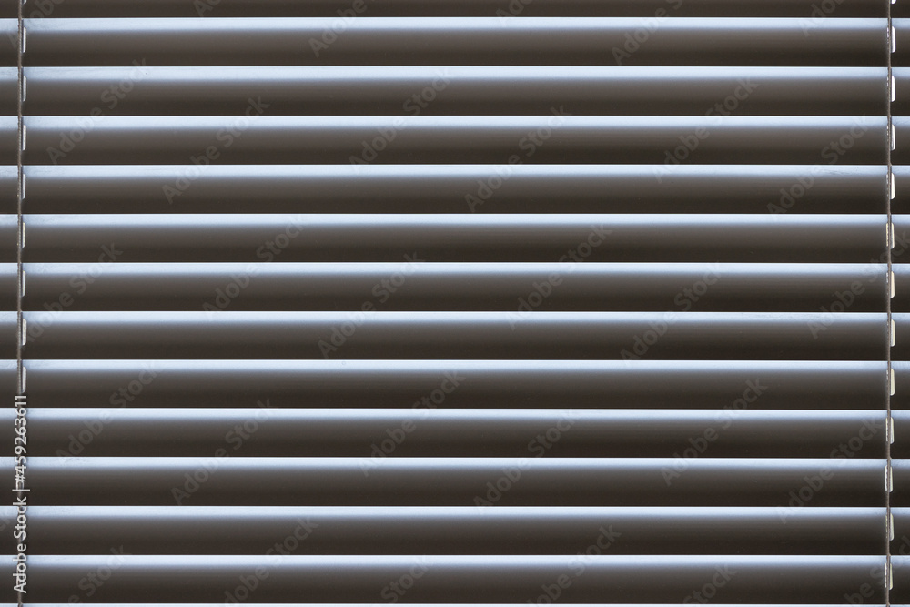 Details of closed silver blinds on a plastic window in the living room. Details of closed silver blinds on a plastic window in the living room.