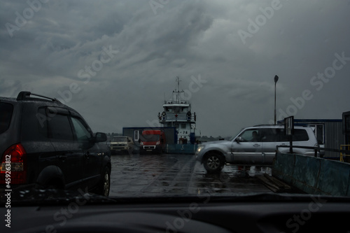 Cars are entering the ferry. wind and rain. bad weather on the road. truck enters an empty sea freight ferry