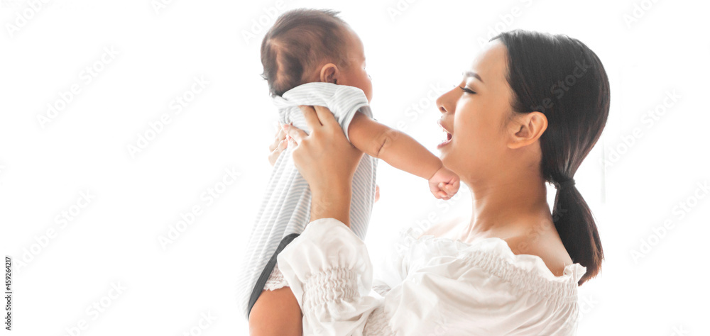 Portrait of enjoy happy love family asian mother playing with adorable little asian baby.Mom touching with cute son moments good time in a white bedroom.Love of family concept Portrait of enjoy happy love family asian mother playing with adorable little asian baby.Mom touching with cute son moments good time in a white bedroom.Love of family concept