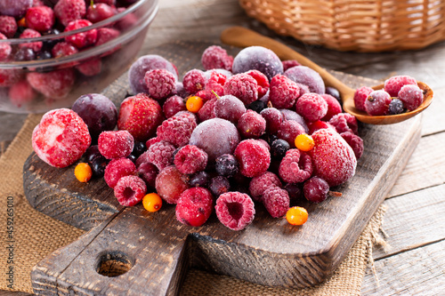Mix of different frozen berries on a cutting board on table. Frozen Food. Food storage