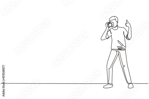 Single continuous line drawing photographer standing, thumbs up gesture, holding photo camera and photographing. Creative profession or occupation. One line draw graphic design vector illustration