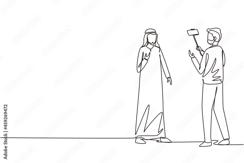 Single continuous line drawing Arab presenter filming video blog with operator. Man blogger, journalists filming with professional smartphone and videographer. One line draw design vector illustration