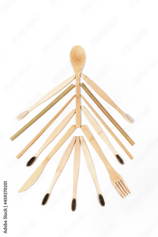 Eco friendly natural bamboo toothbrushes and wooden cutlery laid out as Christmas tree on white. Vertical orientation. Eco friendly natural bamboo toothbrushes and wooden cutlery laid out as Christmas tree on white. Vertical orientation.