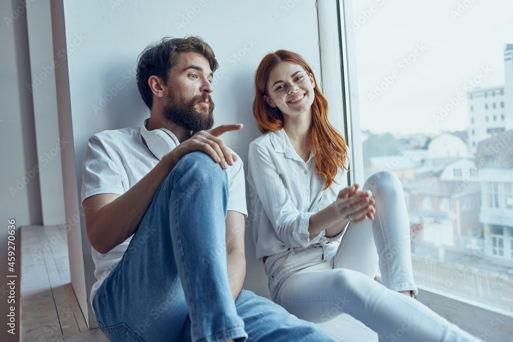 Man and woman sitting on the windowsill romance joy - obrazy, fototapety, plakaty 