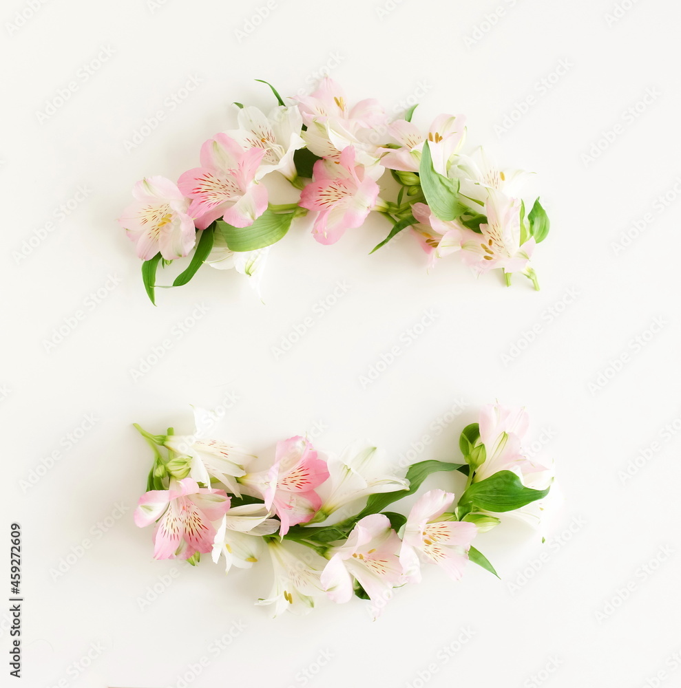 White and pink flowers frame top view on white background with copy space. Alstroemeria flowers backdrop. Poster White and pink flowers frame top view on white background with copy space. Alstroemeria flowers backdrop. Poster