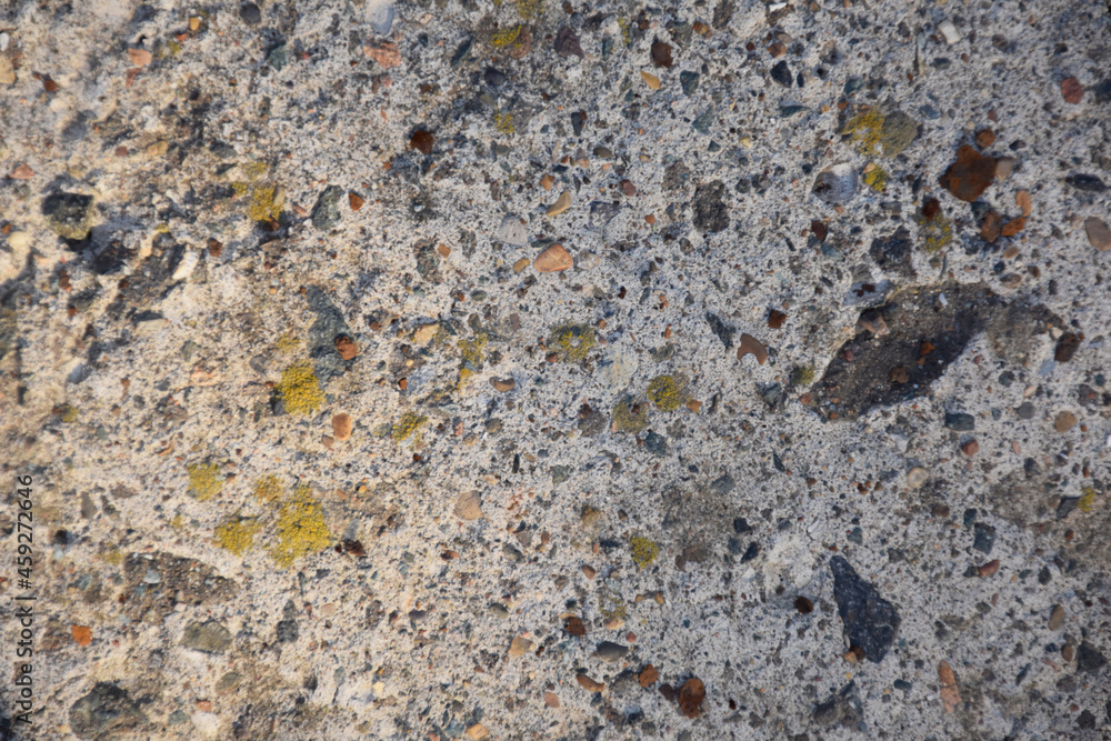 Textrured background of old uneven stone covered with multicolored spots in daylight Textrured background of old uneven stone covered with multicolored spots in daylight
