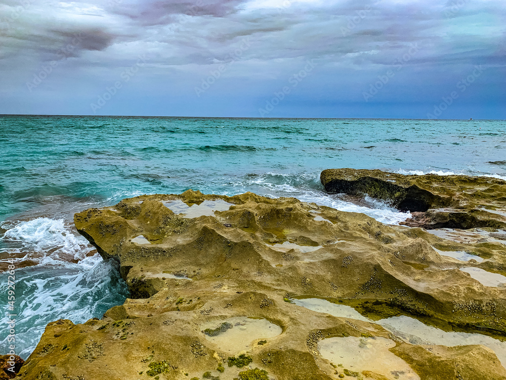 waves crash onto rocky shore on the beach waves crash onto rocky shore on the beach