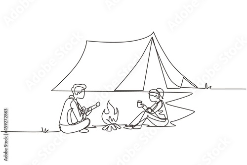 Single continuous line drawing camping couple around campfire tents. Man playing guitar and woman drinking hot tea getting warm near bonfire sitting on ground. One line draw design vector illustration