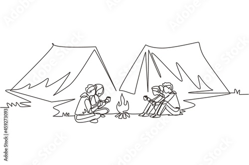 Continuous one line drawing two couple camping around campfire tents. Group of man woman sitting on ground and drinking hot tea getting warm near bonfire. Single line draw design vector illustration