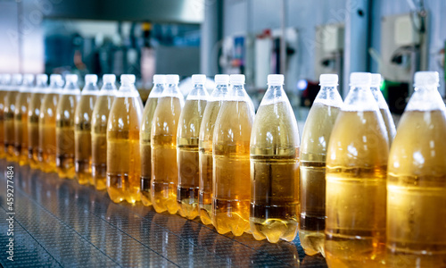 Conveyor belt with bottles for juice or water at a modern beverage plant