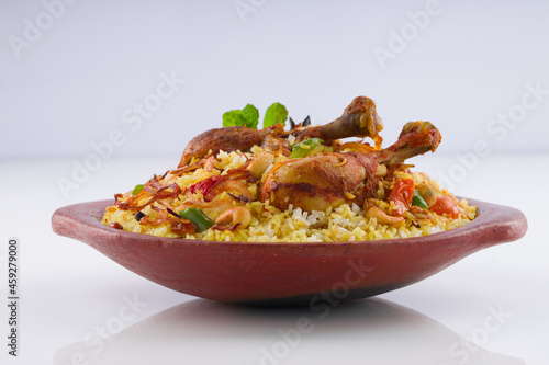 Chicken biryani , kerala style chicken dhum biriyani made using jeera rice and spices arranged in  earthen ware  on white background, isolated photo