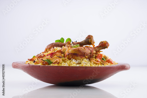 Chicken biryani , kerala style chicken dhum biriyani made using jeera rice and spices arranged in  earthen ware  on white background, isolated photo