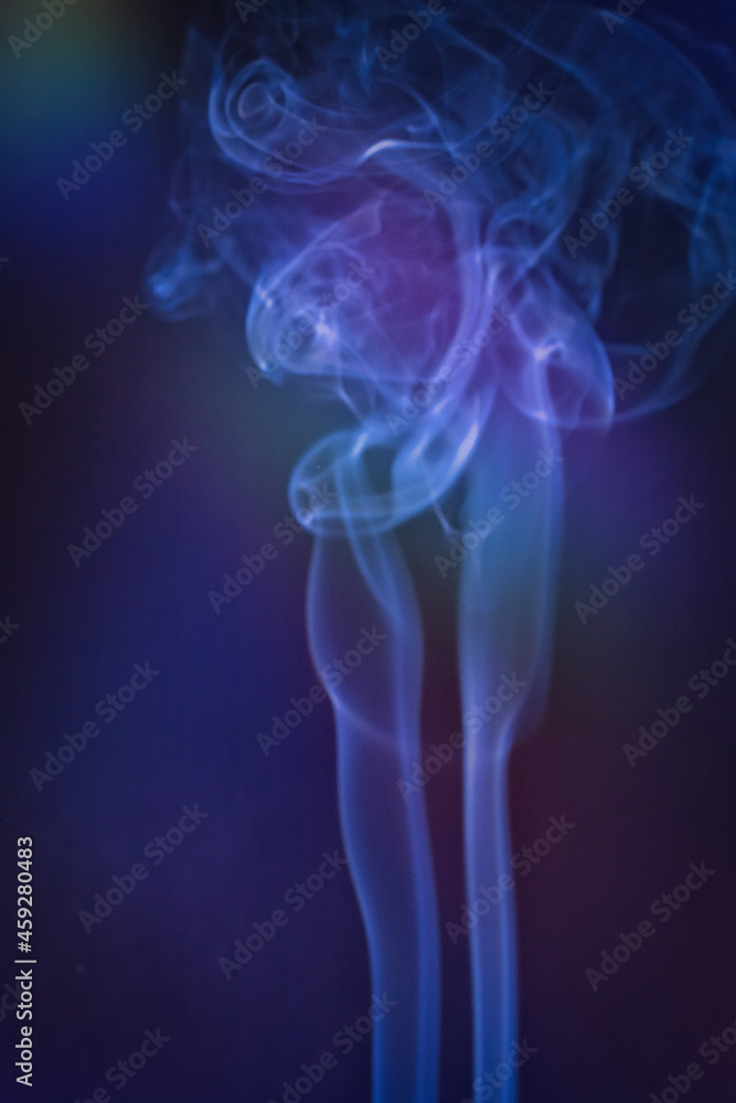 Obraz premium A vertical shot of smoke in colorfull backlight with a blue note