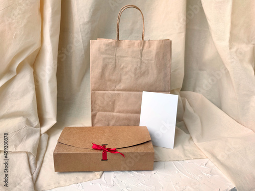 Gift wrapping mockup. Craft bag, craft gift box and postcard