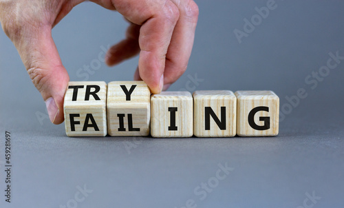 Failing or trying symbol. Businessman turns wooden cubes and changes the word 'failing' to 'trying'. Beautiful grey background. Business, failing or trying concept. Copy space.