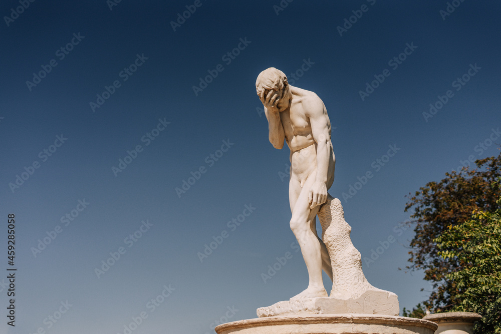 Statue making a facepalm against sky Statue making a facepalm against sky