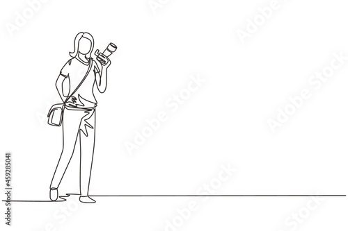 Single one line drawing woman paparazzi or journalist occupation, standing with digital camera and sling bag. Professional photographer taking pictures. Continuous line draw design vector illustration