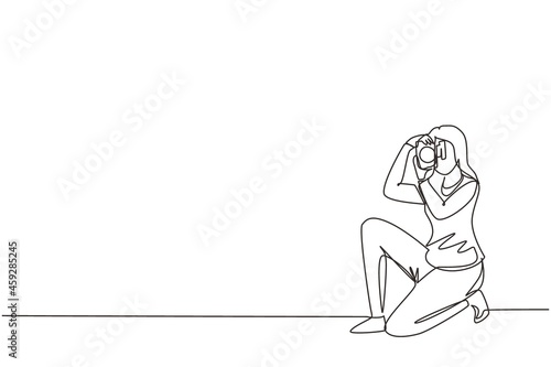 Continuous one line drawing happy photographer is taking photo using dslr camera. Female character standing full length and shooting. Studio photography. Single line draw design vector illustration