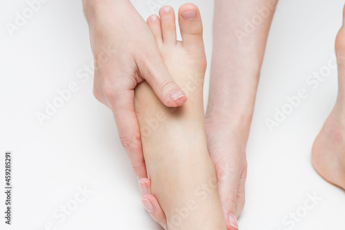 The masseur performs a foot massage for the girl. Orthopedics. Valgus and flat feet.