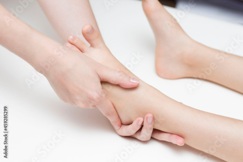 The masseur performs a foot massage for the girl. Orthopedics. Valgus and flat feet.