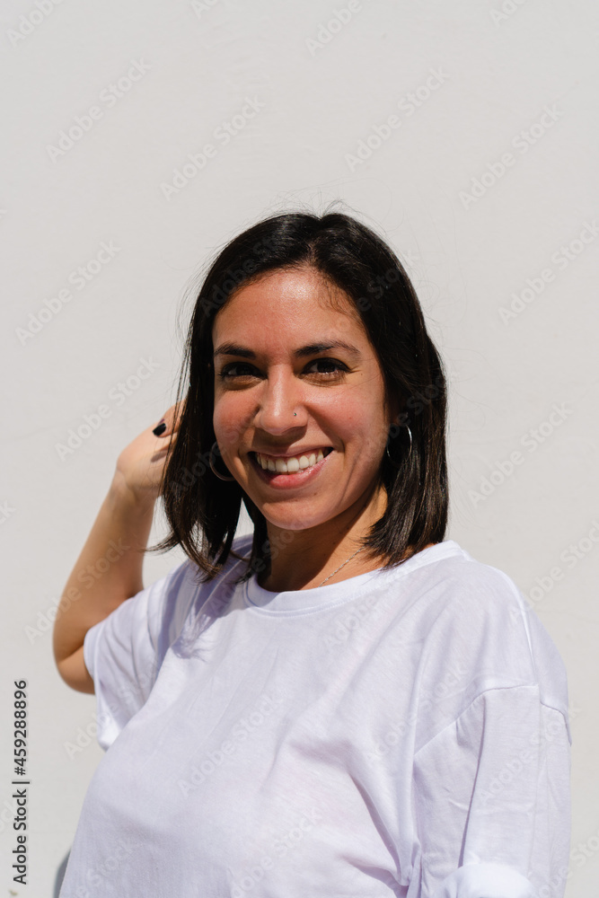 Smiling young latin hispanic woman with short hair looking at the camera with plain white background. Vertical photo. Smiling young latin hispanic woman with short hair looking at the camera with plain white background. Vertical photo.