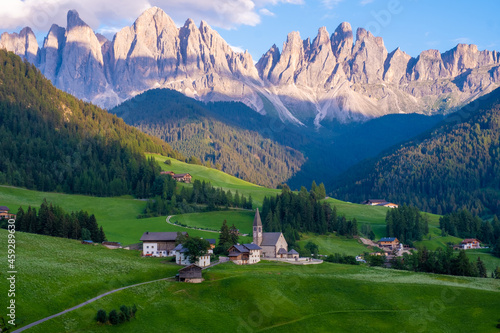 Santa Magdalena village in Val di Funes on the italian Dolomites. Autumnal view of the valley with colorful trees and Odle mountain group on the background. Italy Europe photo