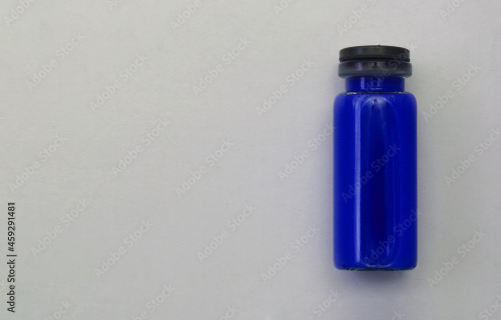 Blue ampoule with drug on light background. Blue ampoule with drug on light background.