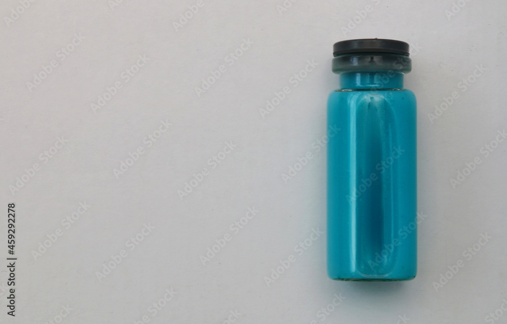 Blue ampoule with medicine on light gray background copi spice. Blue ampoule with medicine on light gray background copi spice.