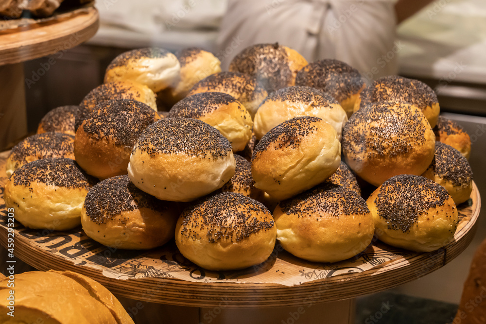 fresh buns with poppy seeds on a wooden tray. bakery in turkey, small business, bread baking fresh buns with poppy seeds on a wooden tray. bakery in turkey, small business, bread baking