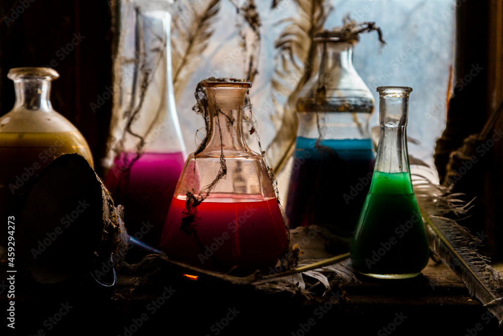 Magic potions in bottles near old rustic window with backlight