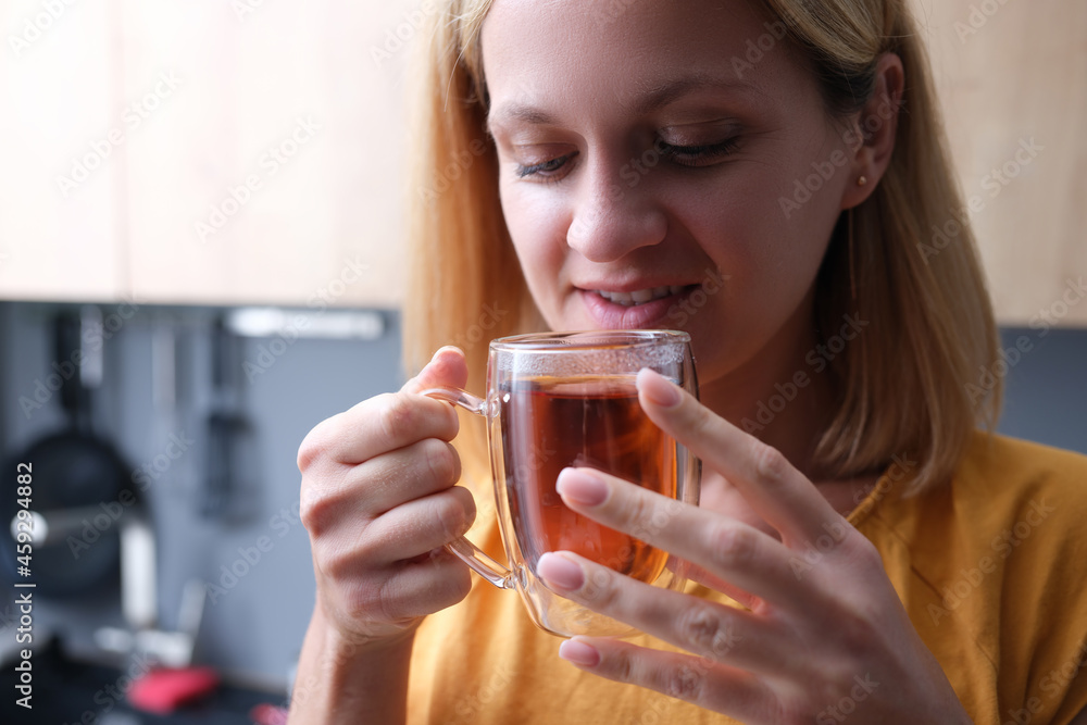 Young woman drinks tea from transparent cup closeup Young woman drinks tea from transparent cup closeup