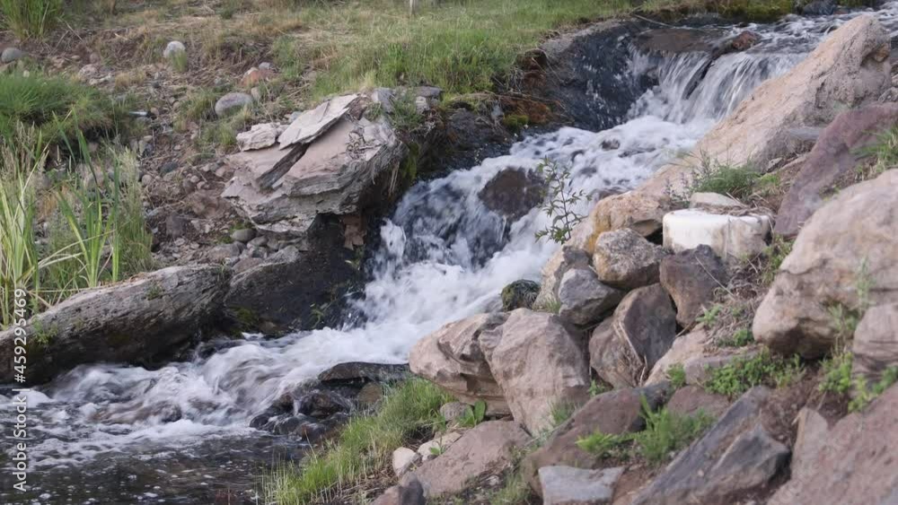 Tiny cascade waterfall on mountain stream by hiking trail Tiny cascade waterfall on mountain stream by hiking trail