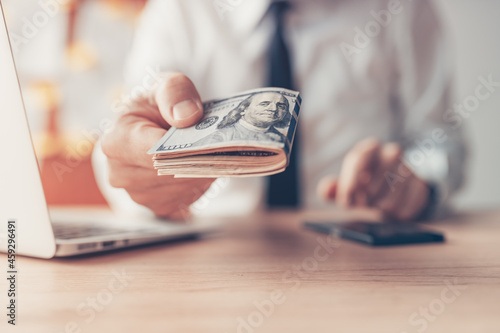 Financial loan, businessman offering US dollar paper currency cash money photo