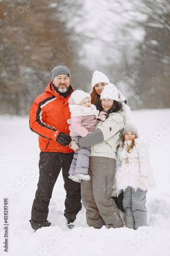 Big family in winter clothes play in winter park
