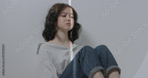 The girl is sitting on the floor and crying because she does not receive support from relatives.