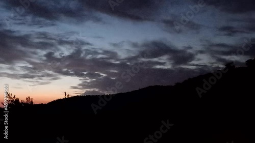 Sun rise behind the mountains timelapse in a cloudy day.