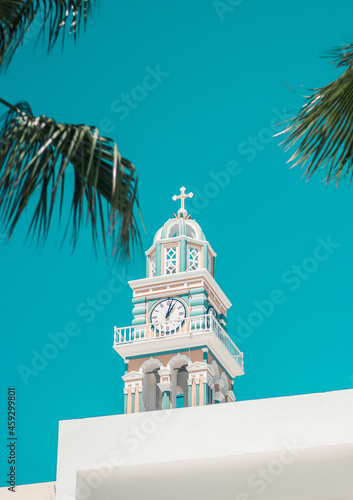 mediterranean clock tower in greece with clear sky and palm leafs