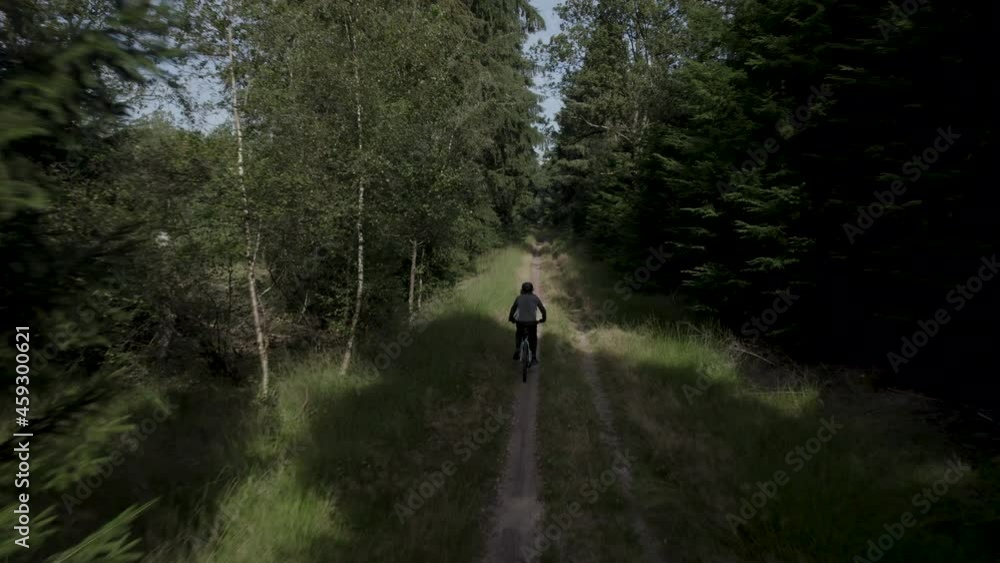Aerial Drone shot of Young mountain biker MTB riding his bike on a beautiful forest path during sunny day Aerial Drone shot of Young mountain biker MTB riding his bike on a beautiful forest path during sunny day