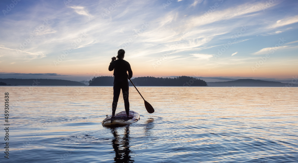 Adventurous Caucasian Adult Woman on a Stand Up Paddle Board is paddling on the West Coast of Pacific Ocean. Sunny Sunrise Sky Art Render. Victoria, Vancouver Island, BC, Canada.
