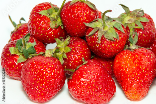 Harvest of fresh ripe strawberries on a white background.