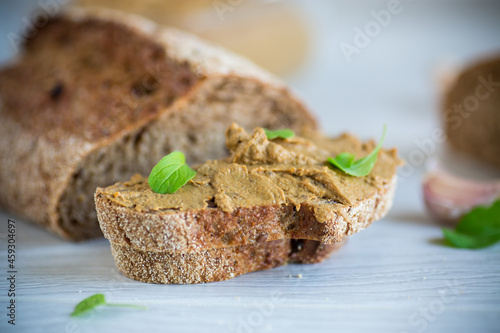 homemade liver pate with bread on a wooden table