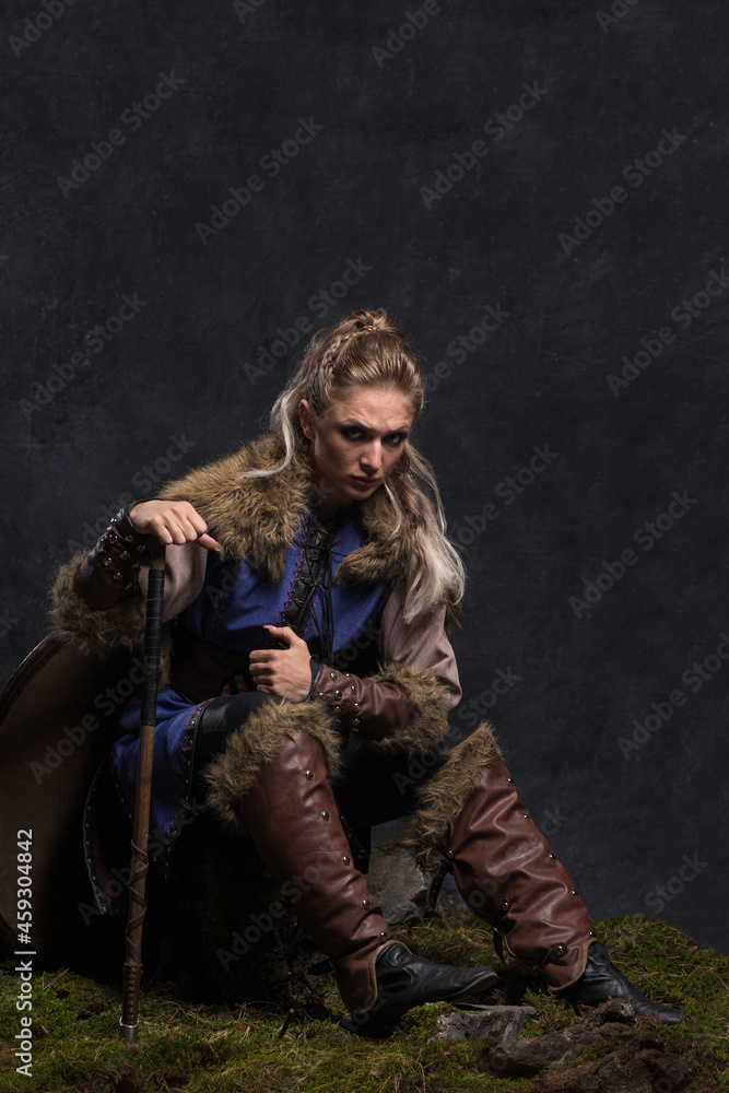Obraz premium Beautiful female viking woman warrior with ax and bow with arrows. Fantasy black concept